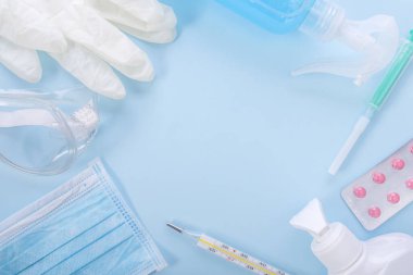 Coronavirus koruması ve tedavisi: tıbbi maske, el antiseptiği, eldivenler ve bardaklar, termometre ve haplar. Yeni koronavirüs enfeksiyonu salgını konsepti. Üst Manzara. kopyalama alanı