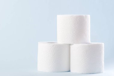 Mavi arka planda beyaz tuvalet kağıdı yuvarlanıyor. Hijyen kavramı.