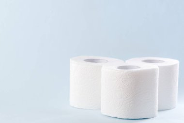 Mavi arka planda beyaz tuvalet kağıdı yuvarlanıyor. Hijyen kavramı.