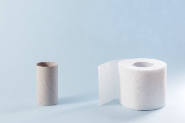 Boş ve mavi arka planda bir rulo tuvalet kağıdı. Kavram Covid-19