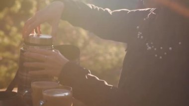 Kadın eli kahveyle termosu açar..