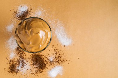 Köpüklü Dalgona kahvesi şeker ve hazır kahvenin arasında duruyor. Üst görünüm.