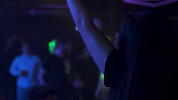 Una chica baila en un club y mira su reloj — Vídeos de Stock