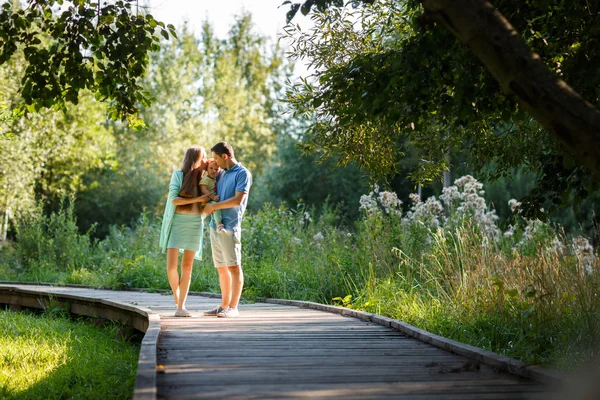 Young family kiss little daughter — Stock Photo, Image