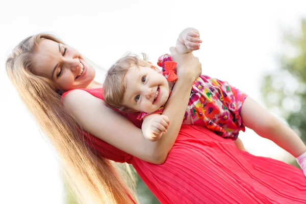 Sorridente madre tiene figlia bambino sulle mani , Foto Stock
