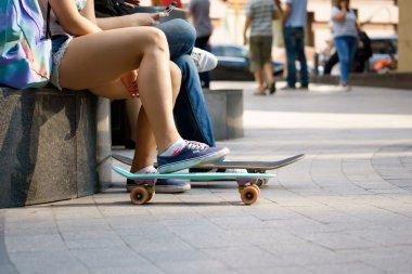 Yaz günü parkta oturan genç kaykaycılar