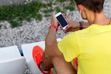 Cep telefonu müzik dinleme sırasında parkta tutan atlet