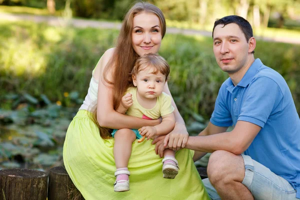 Happy family in park among bushes — Stock Photo, Image