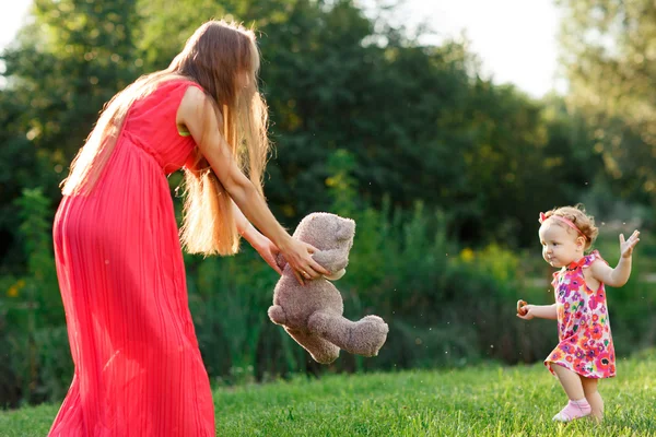 Anyu dress tart a medve kislányom nyáron parkban — Stock Fotó