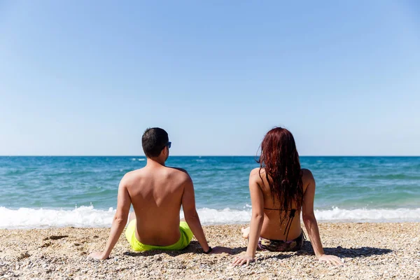 Пара сидить на березі моря — стокове фото