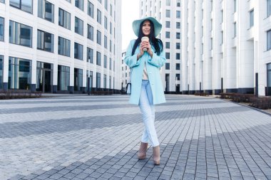 Genç kadın binalar arasında duruyor