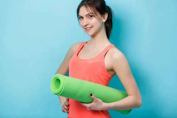 Menina com tapete de fitness torcido — Fotografia de Stock