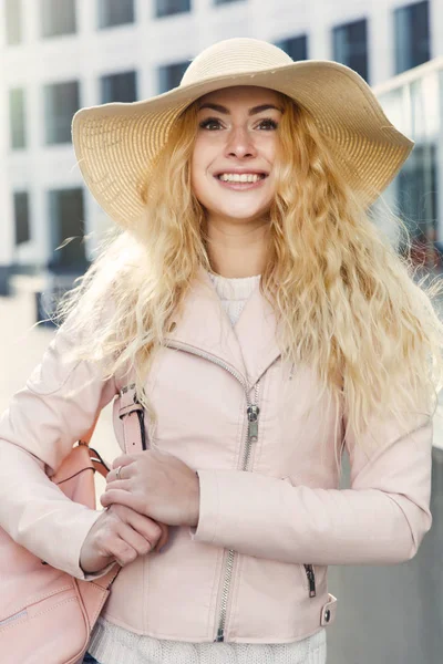 Blonde with hat among buildings — Stock Photo, Image