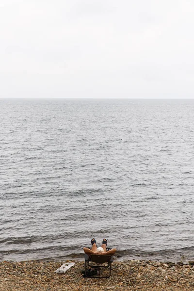 Photo de l'homme en transat sur la plage de galets — Photo