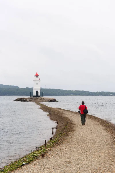 Bild der Küstenmeerzone mit Leuchtturm, Mann zu Fuß — Stockfoto