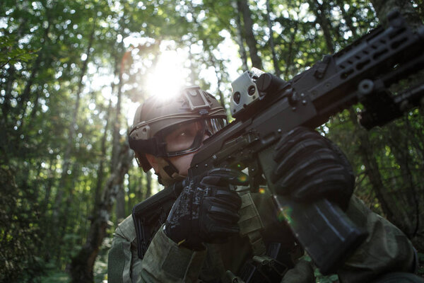 Photo of military man in helmet and with submachine gun