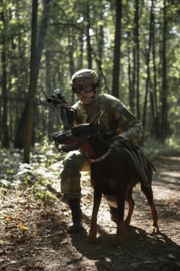 Asker hafif makineli tüfek ve köpek ile kask içinde resmi