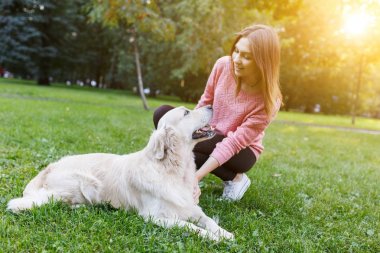 Fotoğraf esmer ile köpek çim üzerinde yalan. Güneş ışığı etkisi
