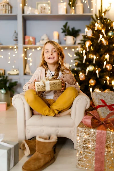 Foto de chica con regalo en las manos fondo de decoraciones de Navidad en el estudio — Foto de Stock