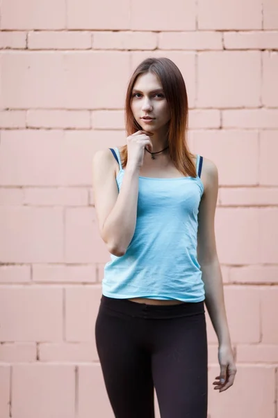 Photo of beautiful sports brunette near pink brick wall — Stock Photo, Image