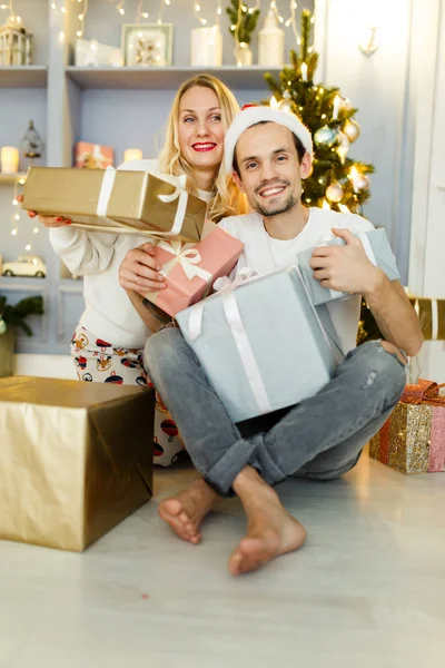 Foto di uomo e donna in cappello Babbo Natale con regalo in scatola — Foto Stock