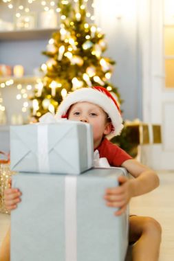 Hediye kutusu arka plan üzerinde Noel süslemeleri ile Noel Baba şapkalı çocuk imajının