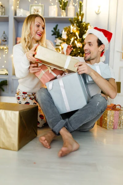 Foto di felice uomo e donna in cappello di Babbo Natale con regalo in scatola — Foto Stock