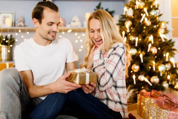 Sweet couple opening Christmas gifts