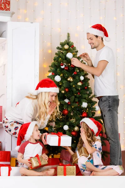 Ευτυχισμένη οικογένεια διακοσμεί χριστουγεννιάτικο πεύκο — Φωτογραφία Αρχείου