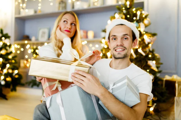 Imagen de hombre y mujer alegres en gorra santa con regalo en caja — Foto de Stock