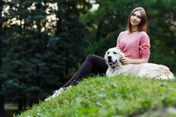 Photo ci-dessous de brune assise avec chien sur pelouse verte — Photo