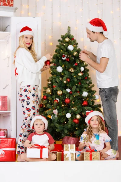 Familia feliz decora pino de Navidad —  Fotos de Stock