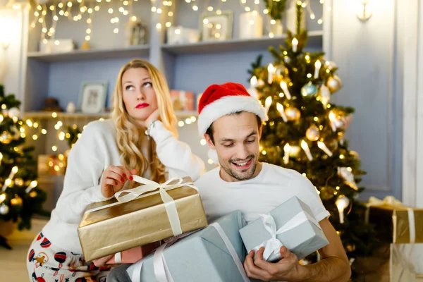 Imagen de hombre y mujer alegres en gorra santa con regalo en caja —  Fotos de Stock