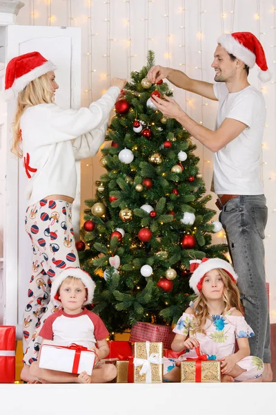 Ευτυχισμένη οικογένεια διακοσμεί χριστουγεννιάτικο πεύκο — Φωτογραφία Αρχείου