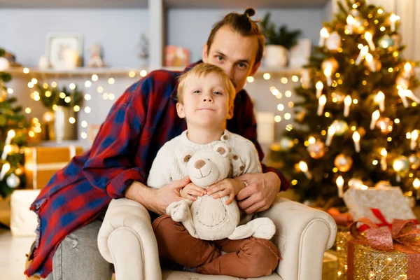 Imagen festiva del padre abrazando a su hijo sentado en la silla —  Fotos de Stock
