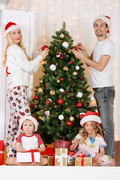 Familia feliz decora pino de Navidad — Foto de Stock