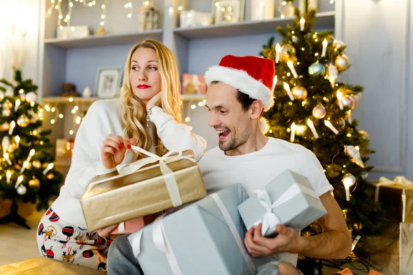 Foto de pareja feliz en Santa Gorra con regalo en caja — Foto de Stock