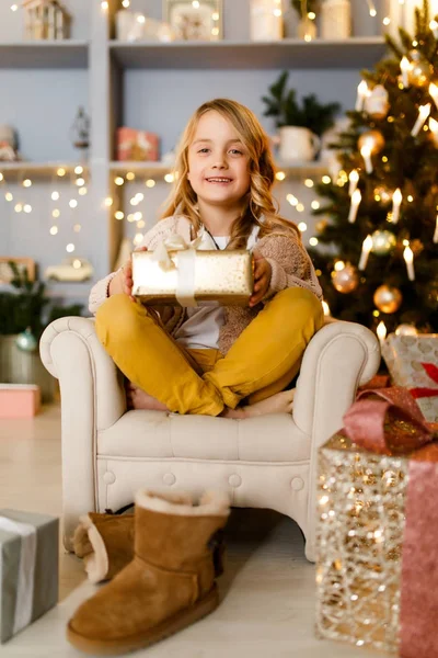 Imagen de chica con regalo sobre fondo de decoraciones navideñas en estudio — Foto de Stock