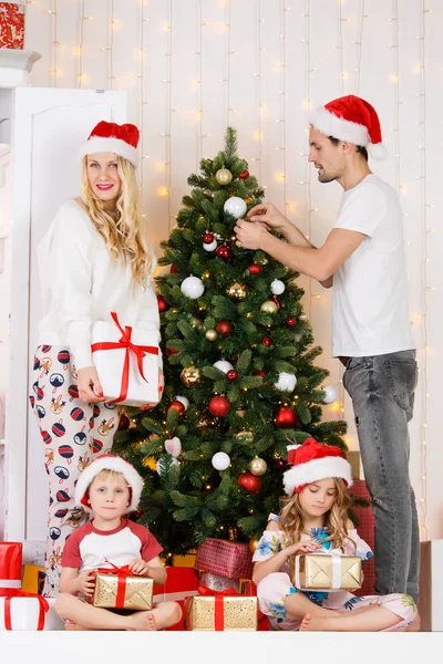 Familia feliz decora pino de Navidad — Foto de Stock