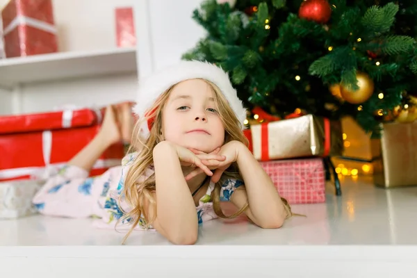 Foto di ragazza a Babbo Natale sdraiata sul pavimento — Foto Stock