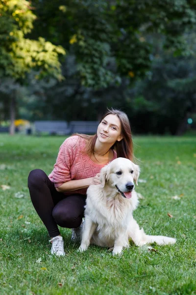 緑の芝生の上に女の子ハグ犬のイメージ — ストック写真