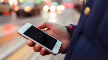 Smartphone ile siyah ekran görüntüsünü el bulanık arka plan üzerinde mans