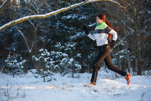 Fiatal sportoló fut át téli erdő-fotó — Stock Fotó