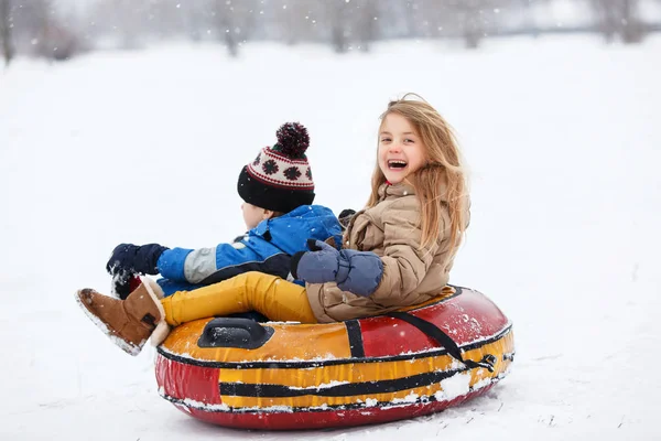 Foto de menina feliz e menino equitação tubulação — Fotografia de Stock