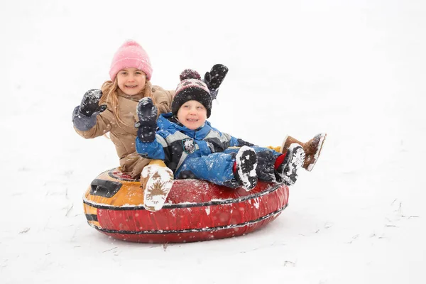 Image of cheerful girl and boy riding tubing — Stock Photo, Image