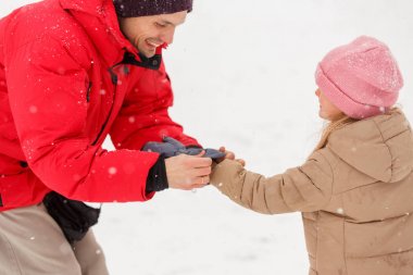 Onun babası soyunma kızı mittens kış Park görüntüsünü