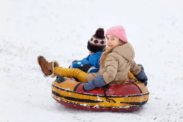 Picture of happy girl and boy riding tubing — Stock Photo, Image
