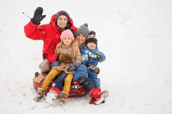 Imagem de família feliz com filha e filho sentados na tubulação no inverno — Fotografia de Stock