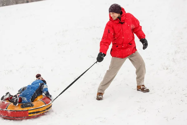 Photo de l'homme chevauchant son fils le jour de l'hiver — Photo