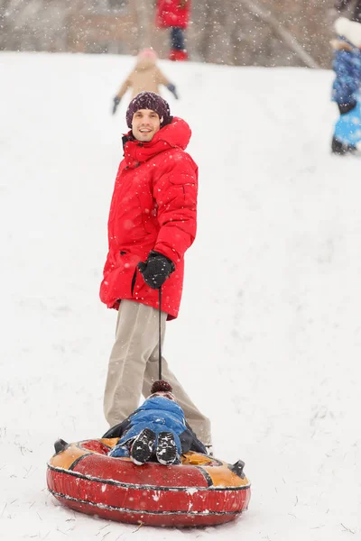 Image de l'homme roulant son fils le jour de l'hiver — Photo